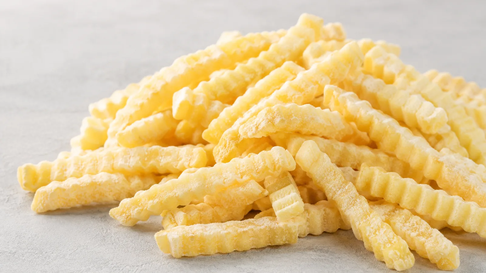 Junsheng Wellenschnitt-Pommes mit geriffelter Textur auf einem Foodservice-Tablett